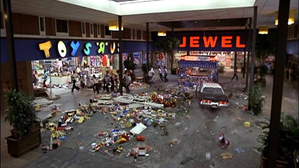 A scene from "The Blues Brothers" featuring a chaotic mall with debris and a crashed car.
