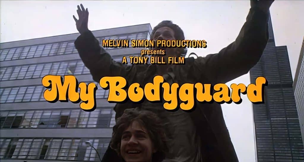 Scene from the 80s movie "My Bodyguard" showing the title and credits against a cityscape background.