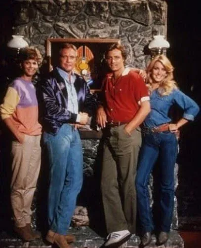 Four people standing in front of a stone mantle.