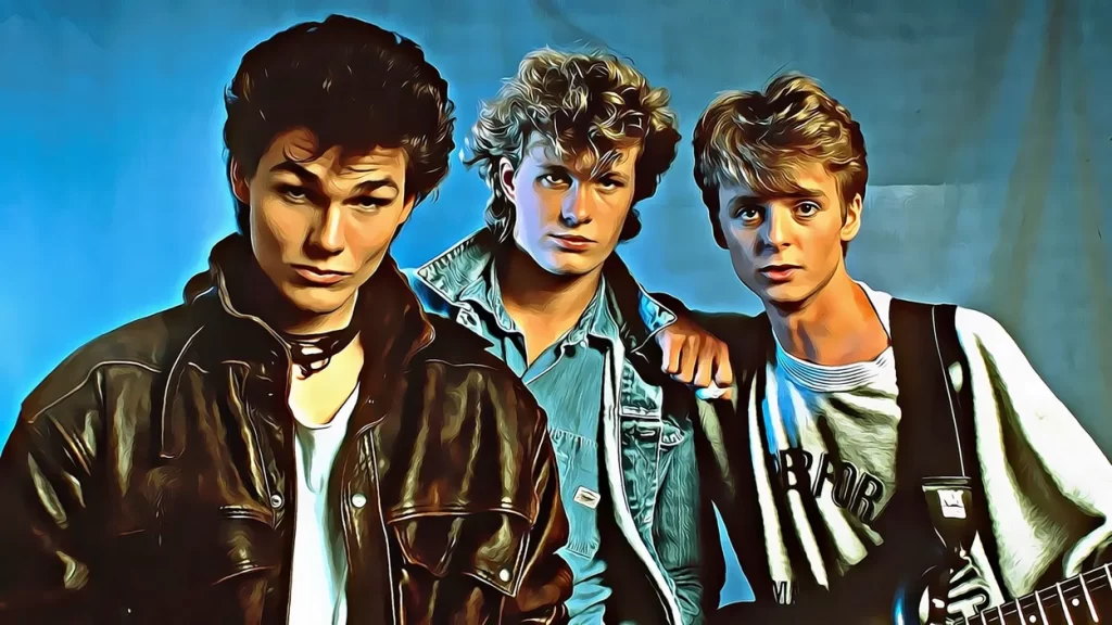 A-ha band members Morten Harket, Magne Furuholmen, and Paul Waaktaar-Savoy posing together in an 80s-style portrait.