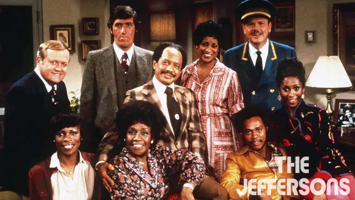 The main cast of "The Jeffersons" posing together in a living room setting.